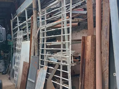Prateleiras com tubos, chapas e grades metálicas no pátio