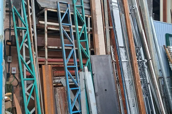 Peças e estruturas metálicas apoiadas na parede do pátio da Lapa